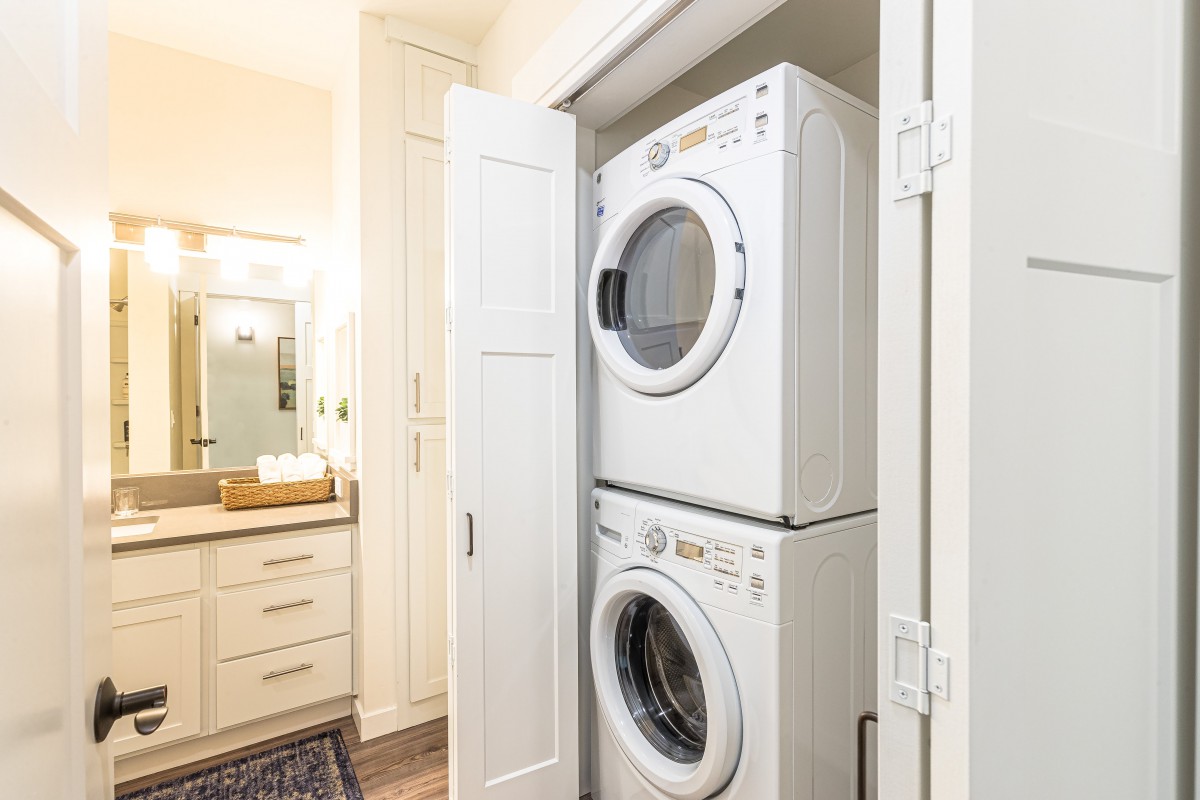 A compact laundry area with stacked washer and dryer units in a utility closet.