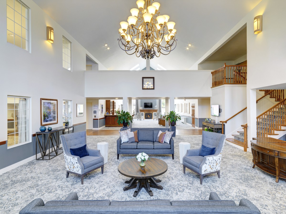 Spacious living room with elegant chandelier and modern seating arrangement.