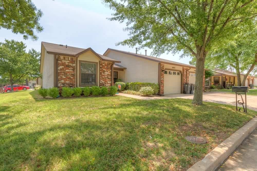 A suburban house with a brick exterior and a well-maintained front yard.