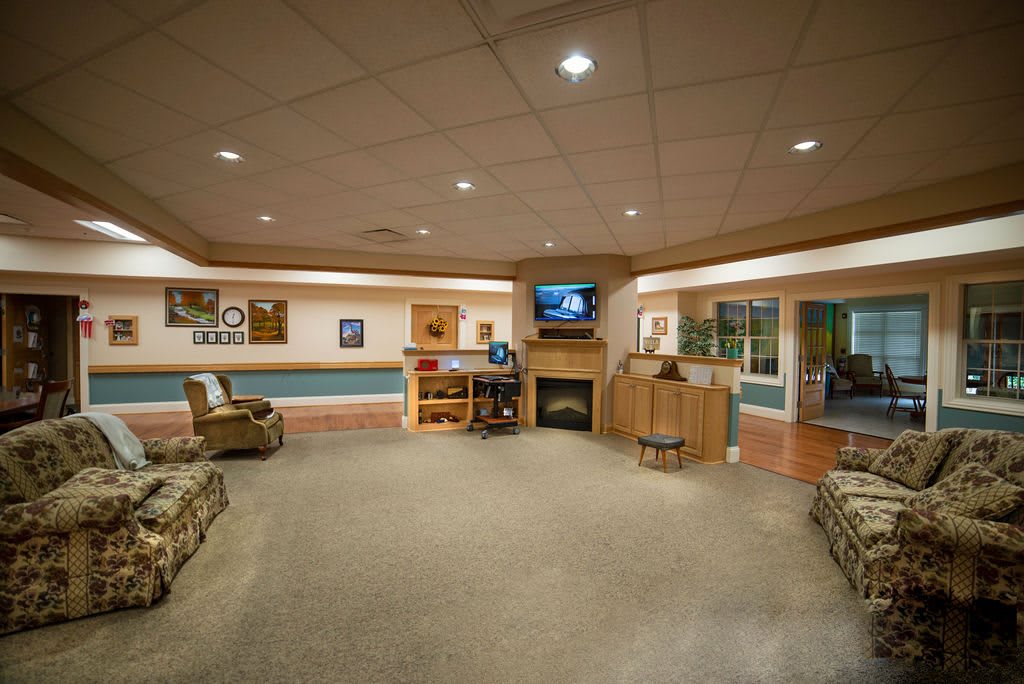 A spacious living room with comfortable seating, a television, and a cozy fireplace.