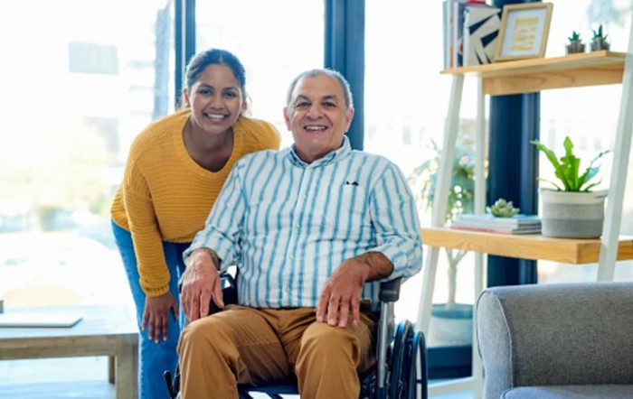 A cheerful moment between two people, with one seated in a wheelchair.