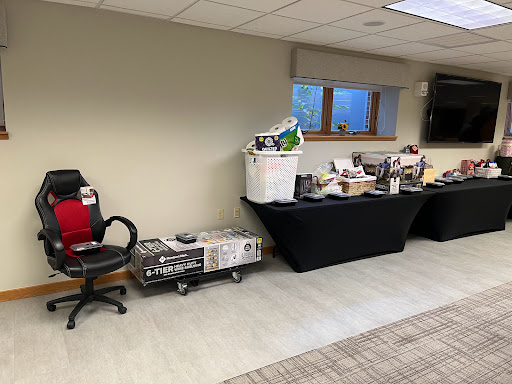 An organized workspace featuring chairs and a table with various items displayed.
