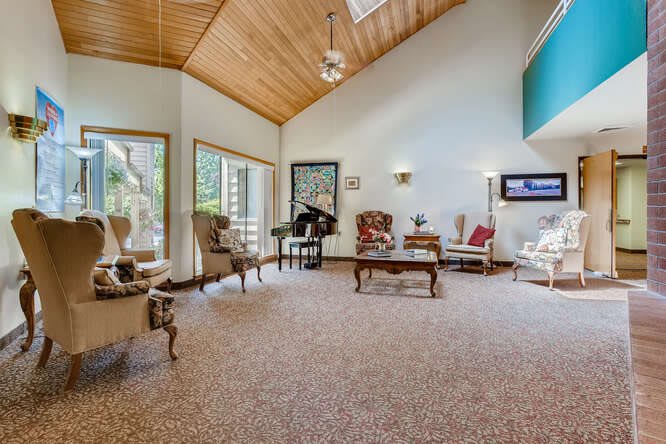 A spacious living room with a vaulted wood ceiling, elegant furniture, and ample natural light.