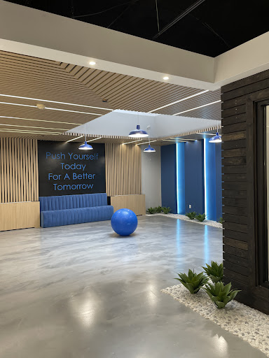 A modern and inviting workspace lobby featuring a blue seating area and decorative plants.