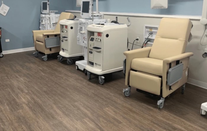 A clinical setting with dialysis machines and chairs for patient treatment.