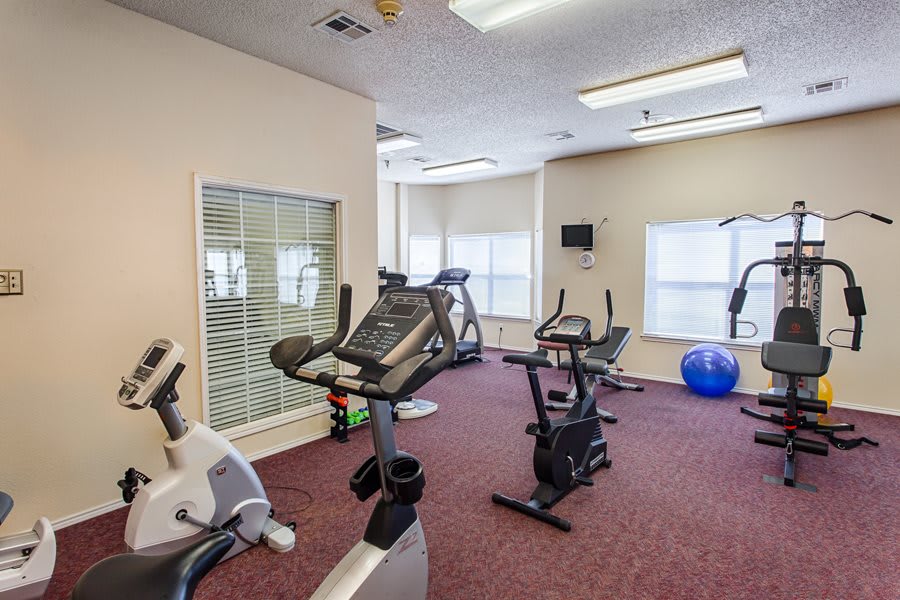A small gym with exercise equipment including stationary bikes and cardio machines.