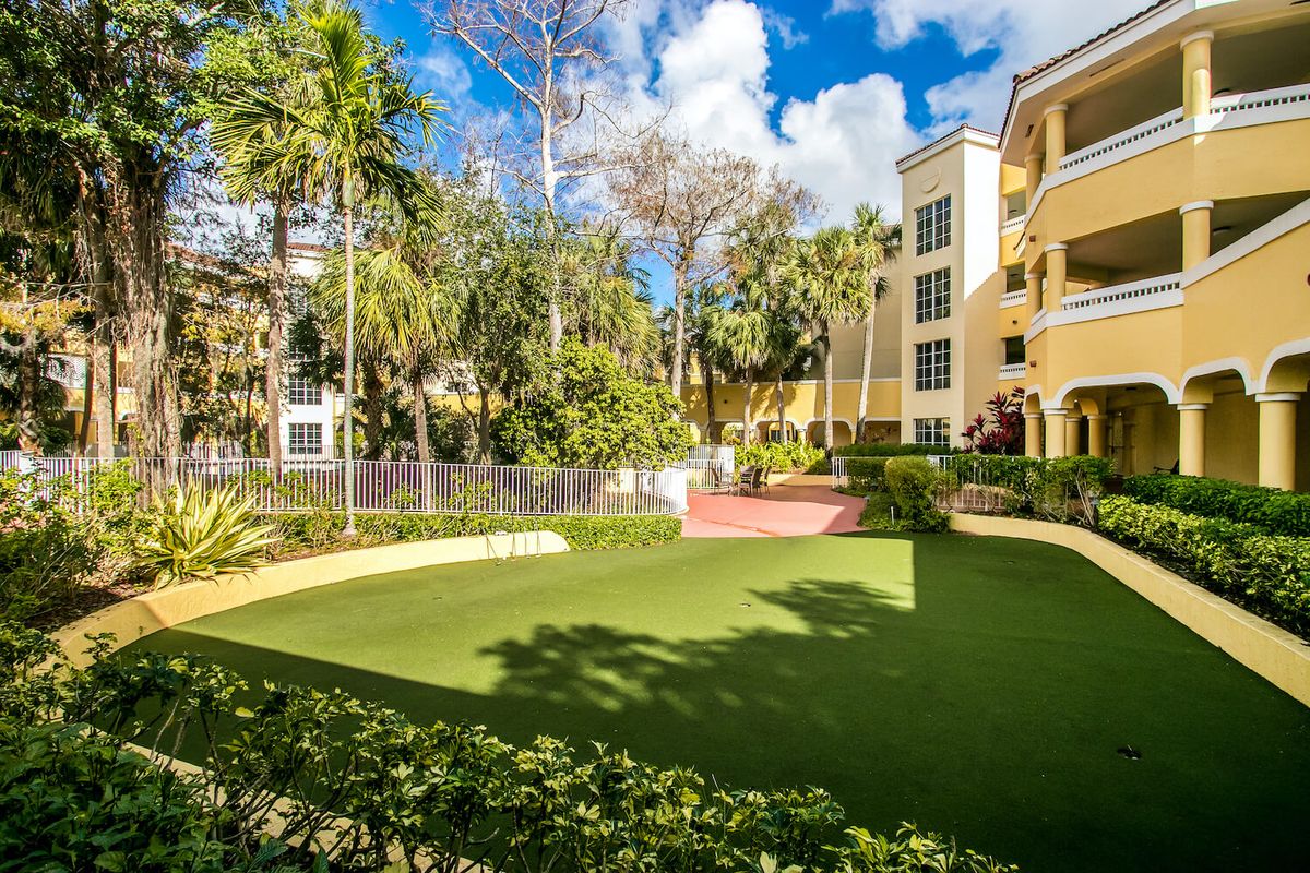 A well-maintained garden area in an apartment complex surrounded by lush greenery.