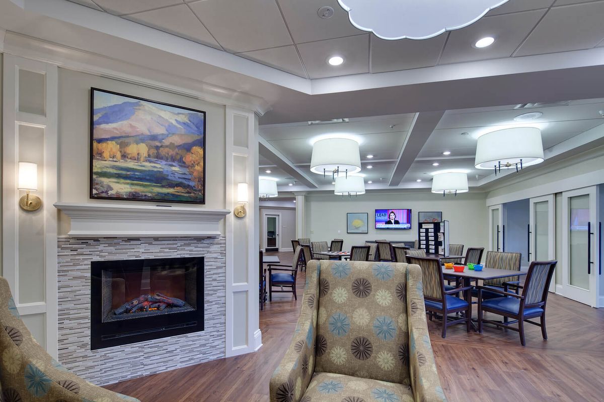 A cozy living room with a fireplace, comfortable seating, and elegant lighting.