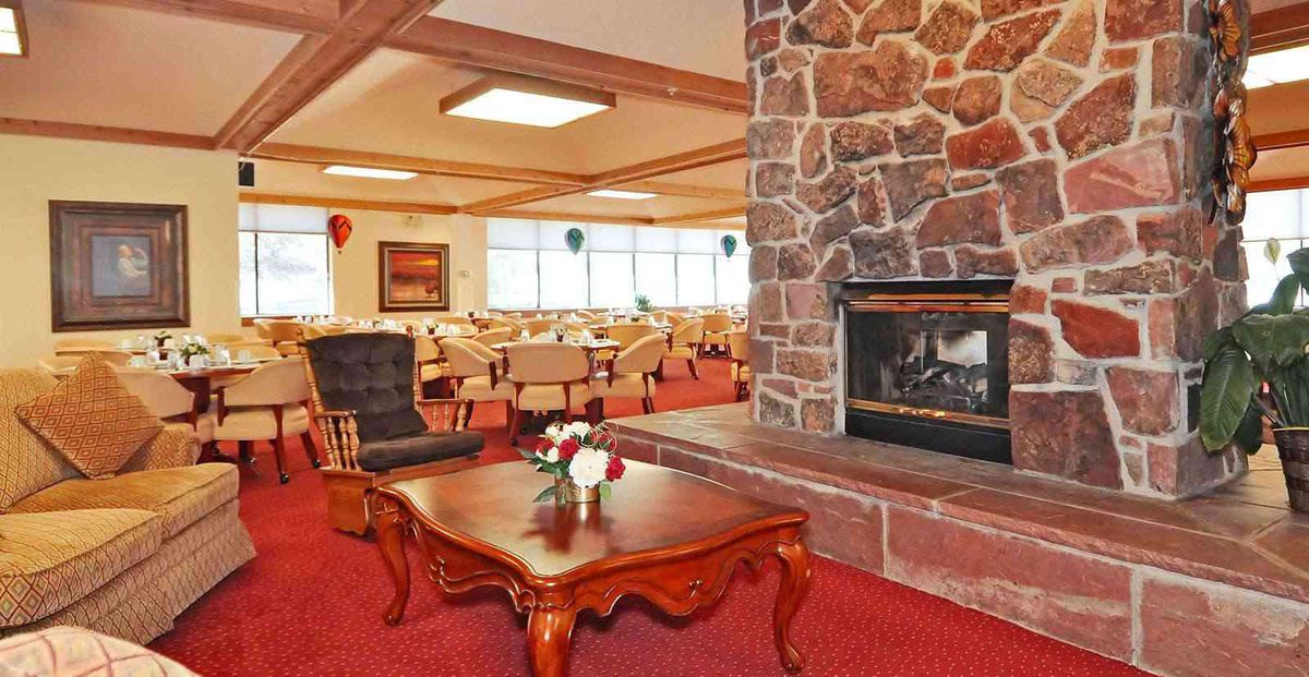 A cozy restaurant interior featuring a stone fireplace and elegant seating arrangement.