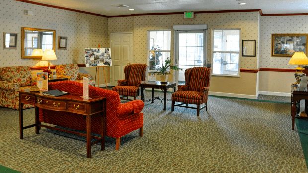 A cozy living room with red upholstered chairs and a coffee table.