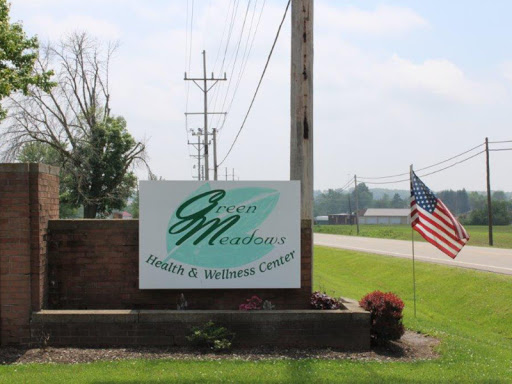 Welcome sign for a farm and seed company, featuring greenery and an American flag.