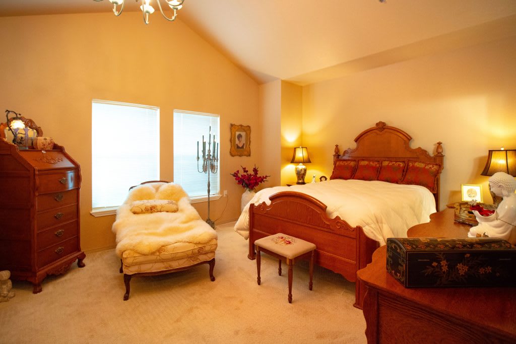 A cozy, classic-style bedroom with elegant furniture and warm lighting.