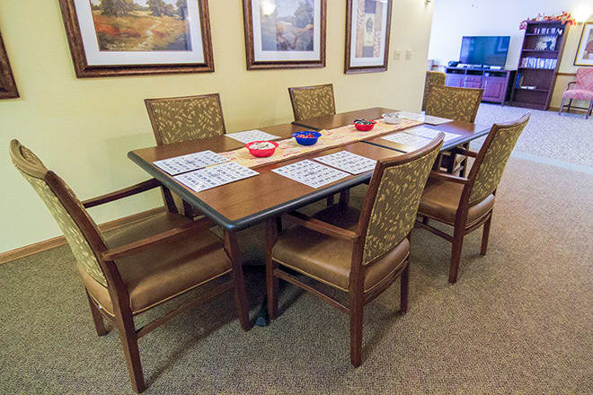 A dining room setup with a table, six chairs, placemats, and decorative bowls.