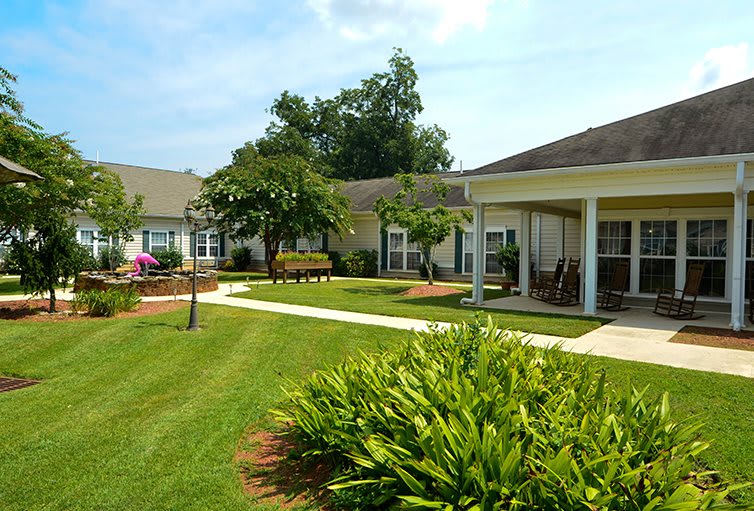 A scenic view of a garden and pathway outside a building on a sunny day.