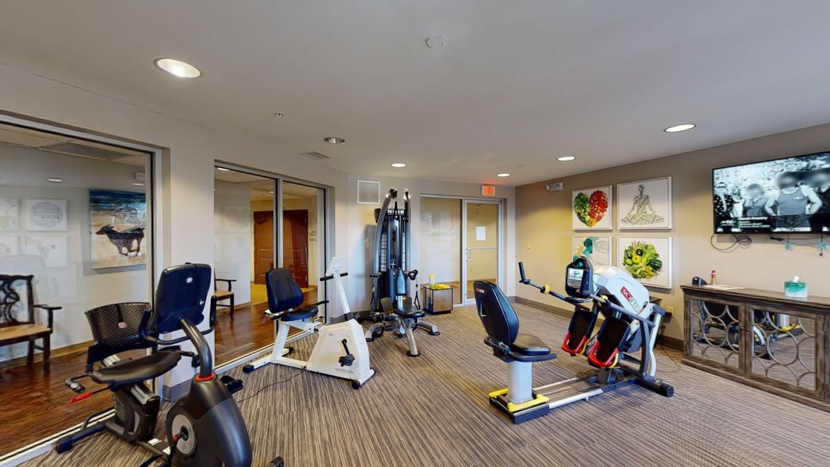 A well-equipped gym room with various exercise machines and ample space for workouts.