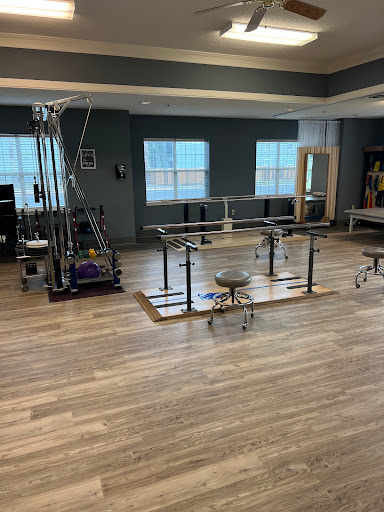 A well-equipped physical therapy room featuring various exercise equipment for rehabilitation.