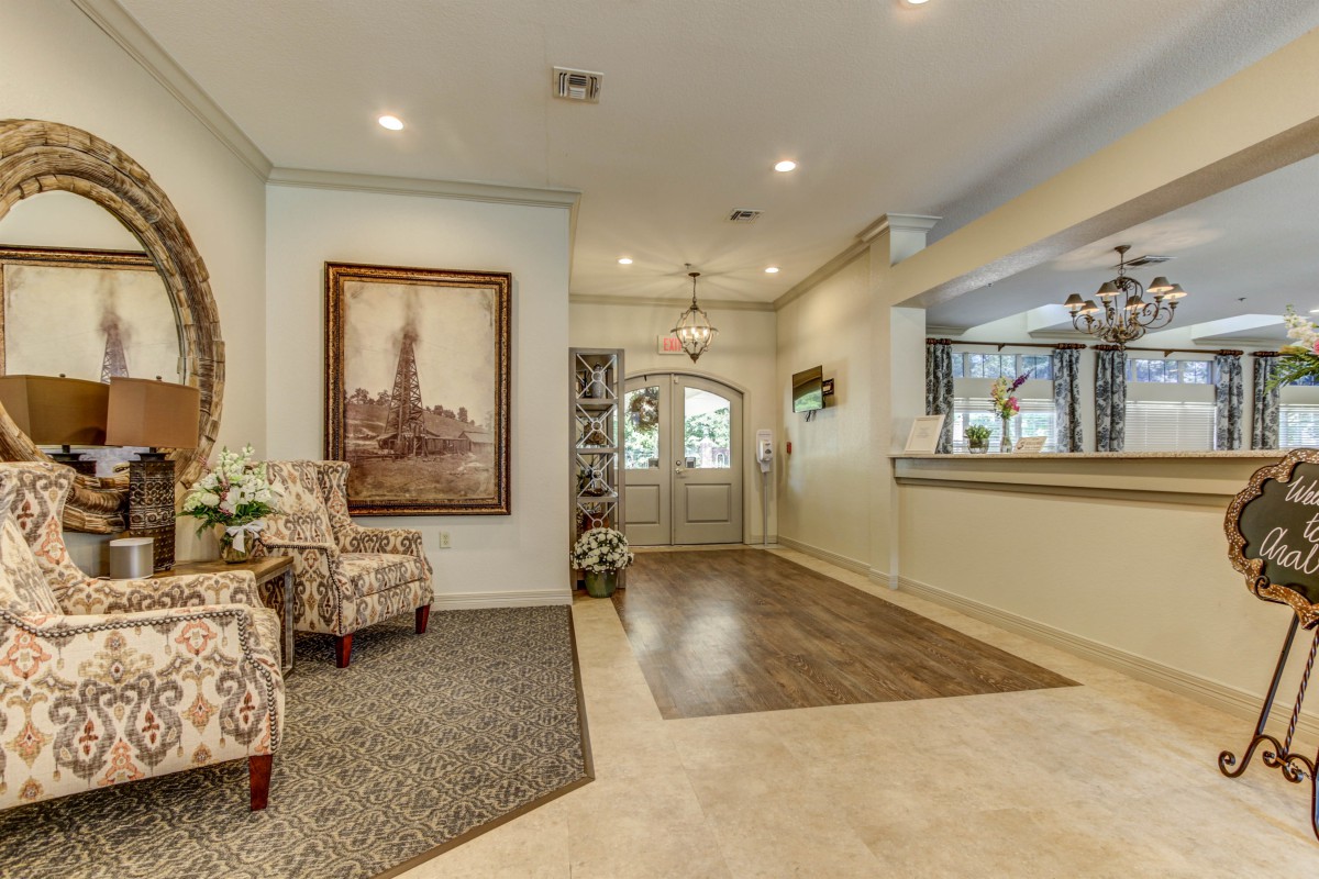 A tastefully decorated foyer featuring artwork, chairs, and elegant lighting.