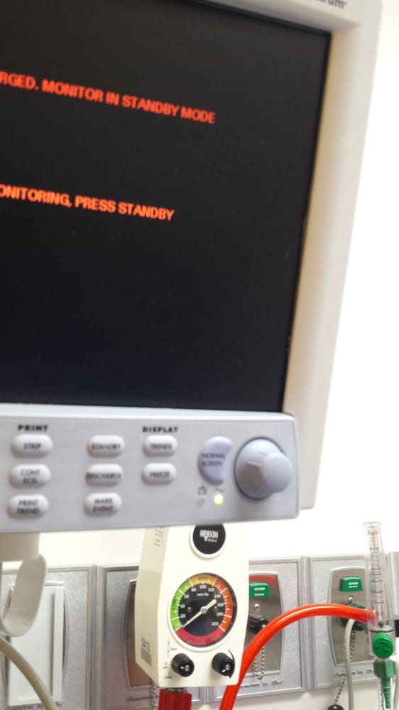 A medical monitor with a display screen showing text.