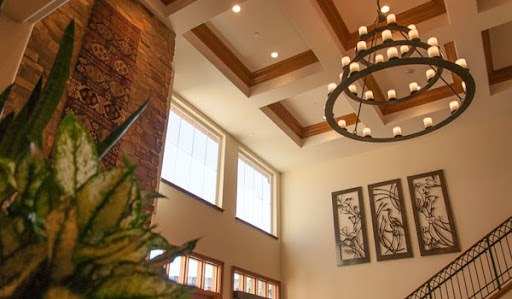 A beautifully designed lobby with a chandelier and large windows allowing natural light to illuminate the space.
