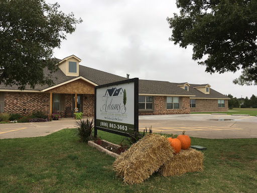 A welcoming building adorned with fall decorations, featuring pumpkins and hay bales in front of the sign.