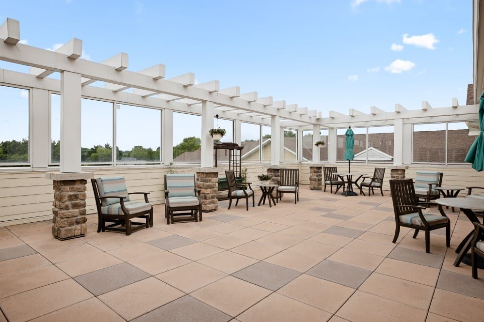 A spacious outdoor terrace with comfortable seating and a pergola.