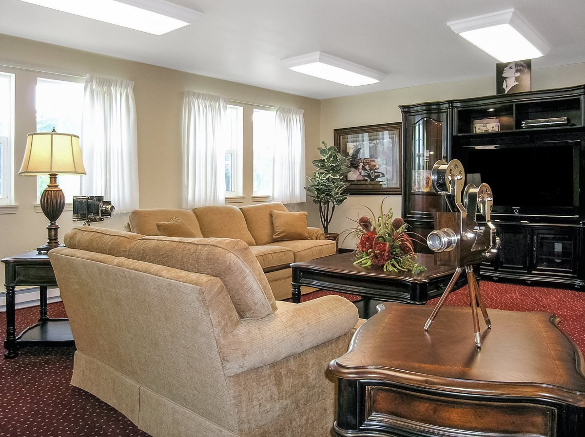 A cozy living room with a large beige sofa and elegant furniture, creating a warm and inviting atmosphere.