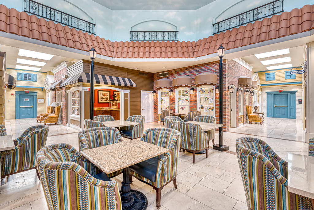 A cozy indoor seating area with striped upholstered chairs and tables, set in a decoratively designed space.