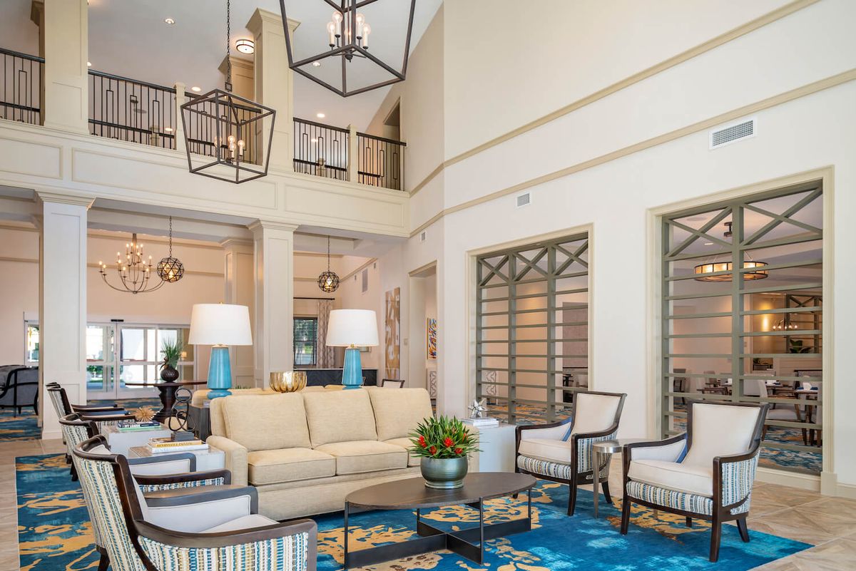 A modern and spacious living room with neutral-toned furniture and elegant lighting.
