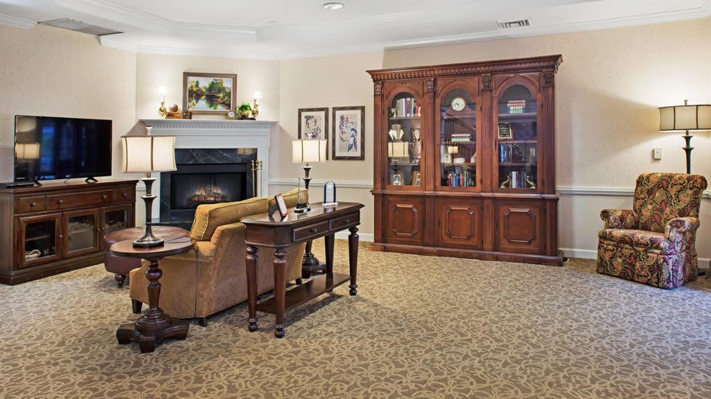 A cozy living room featuring a large wooden bookshelf, a comfortable sofa, and a warm fireplace.