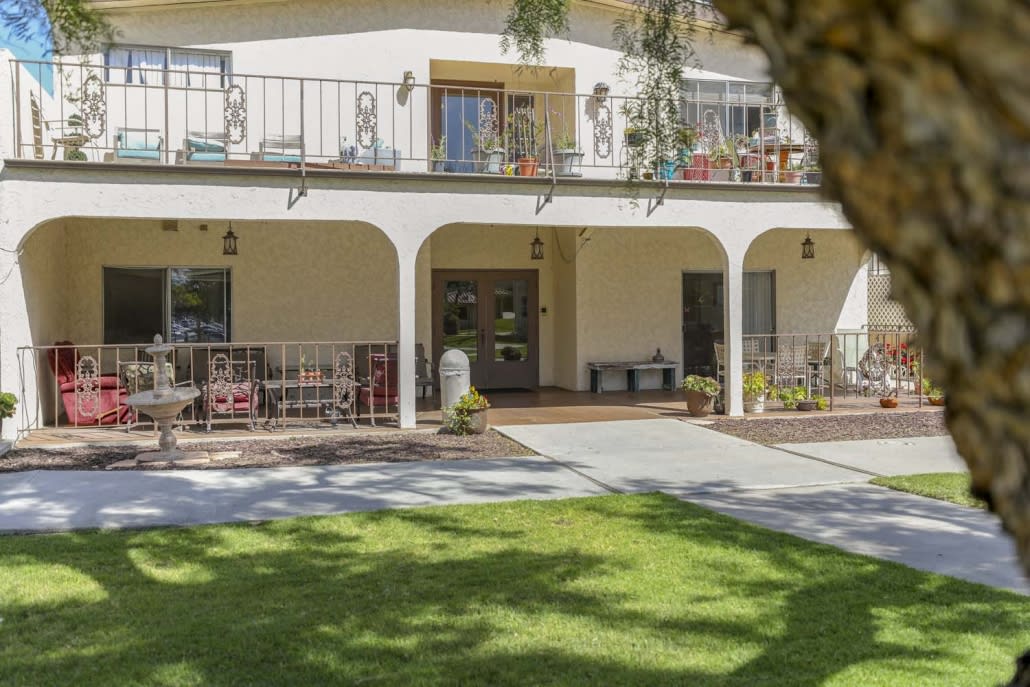 A two-story house with balconies and a well-maintained lawn.