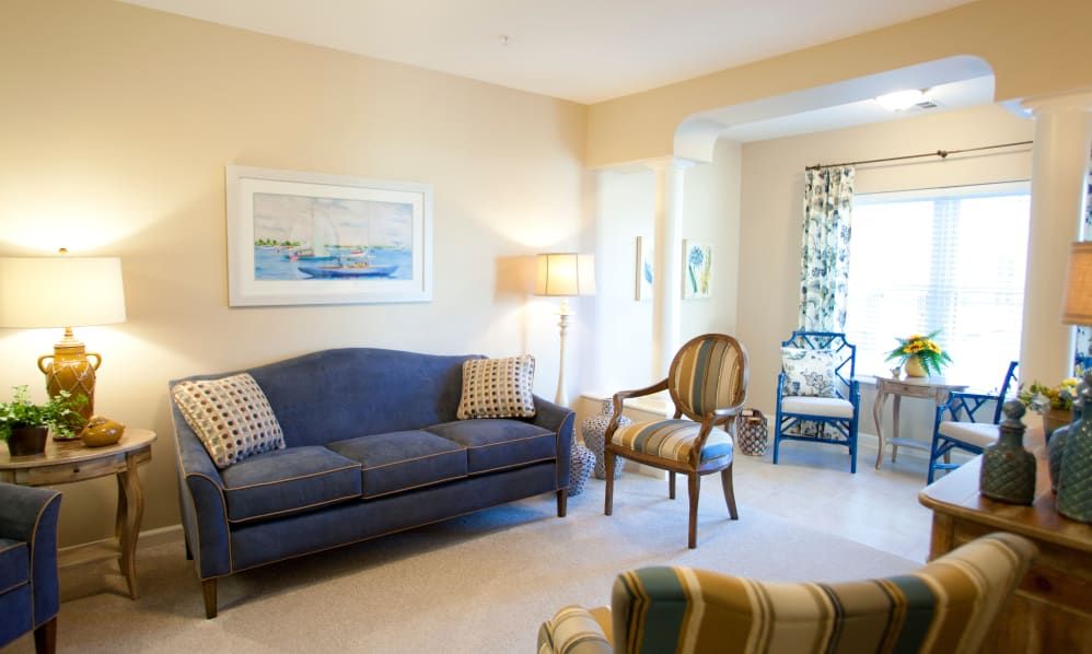A cozy living room with a blue sofa, armchair, and stylish decor.