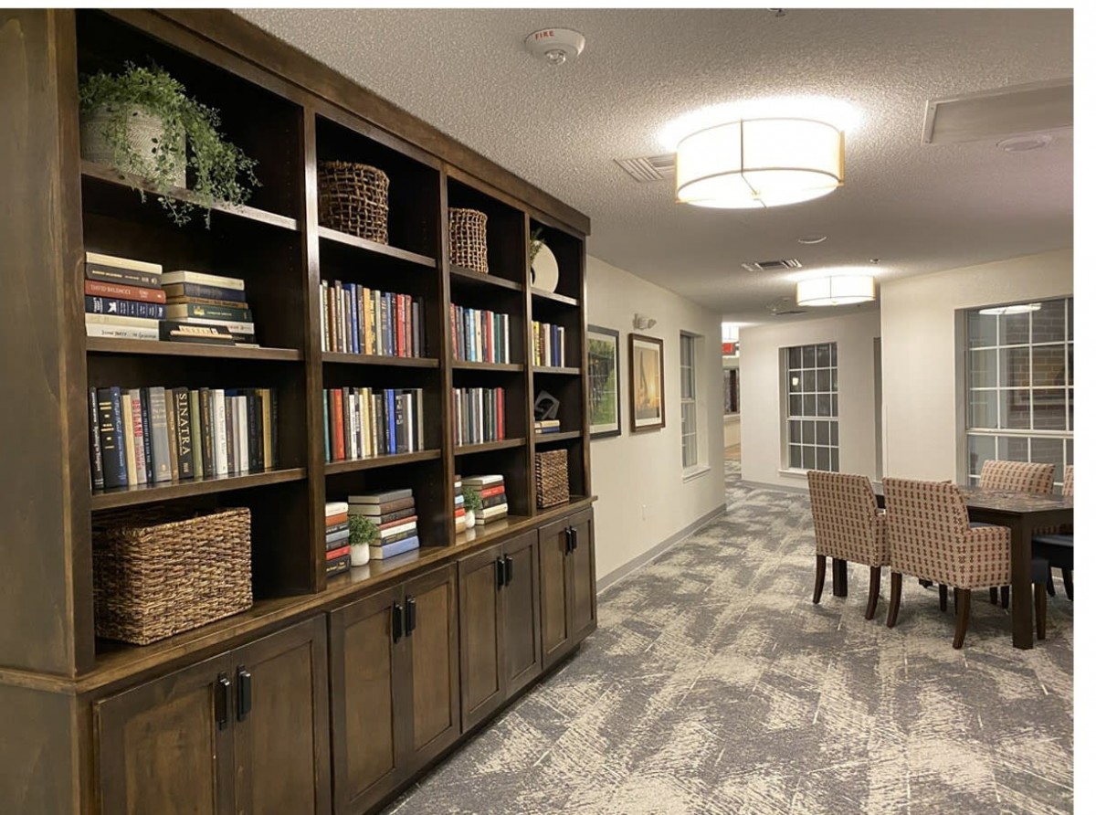 A cozy library hallway with a well-stocked bookshelf and comfortable seating.