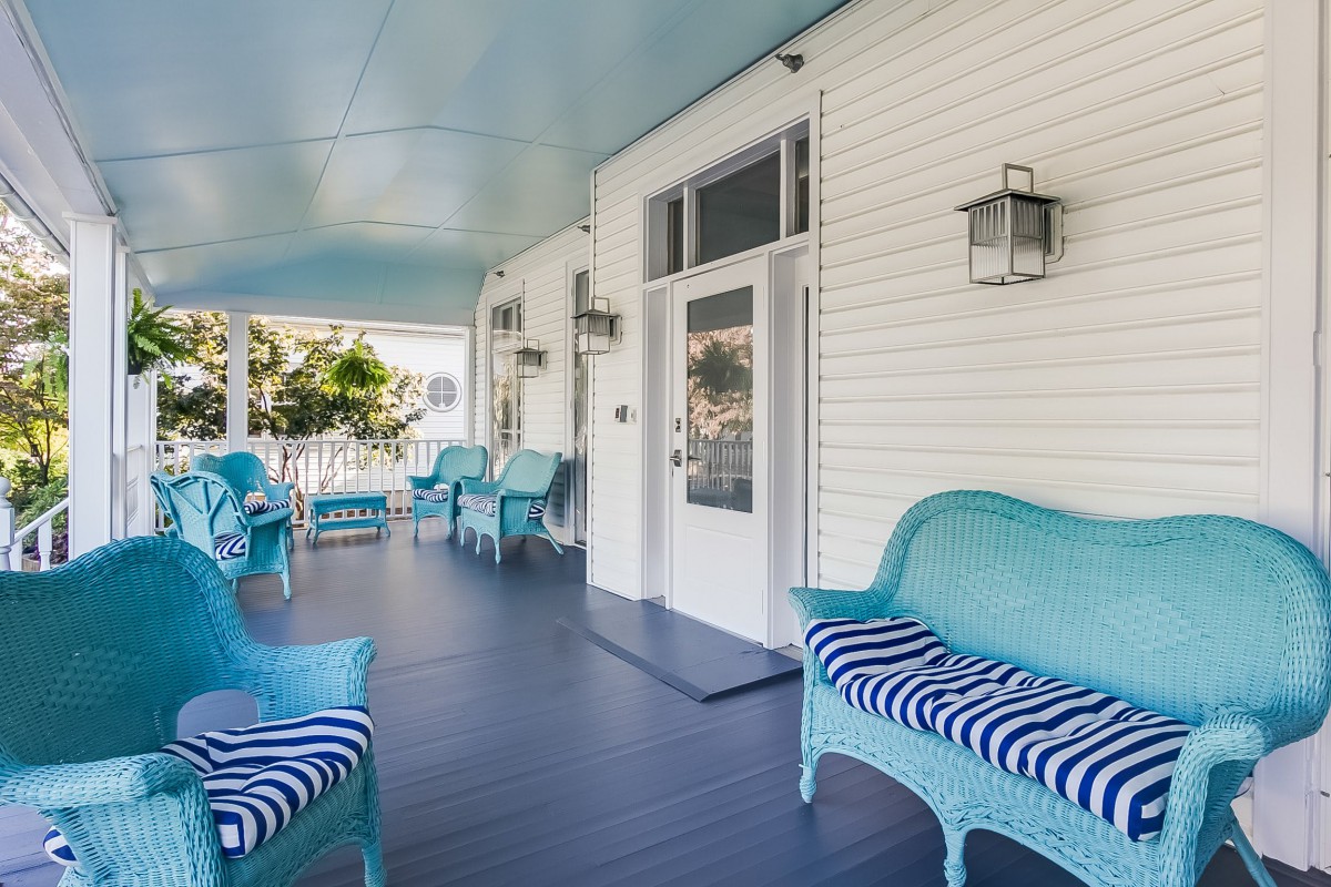 A charming porch with blue cushioned furniture and traditional design elements.