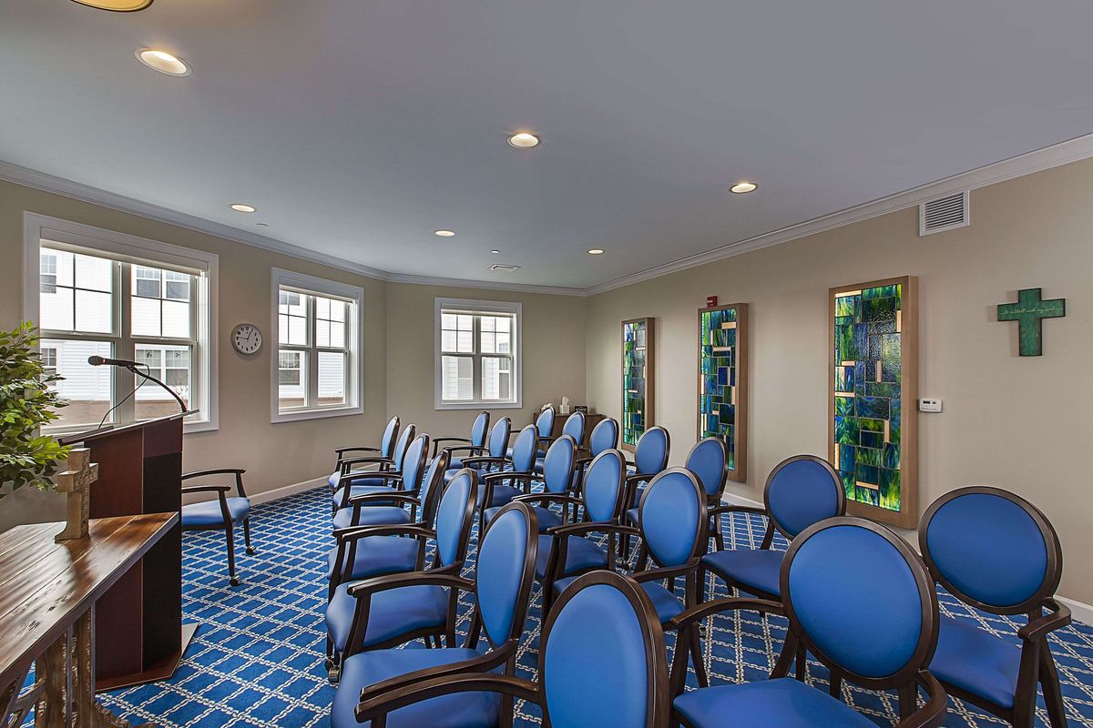 A well-arranged meeting room with blue chairs and large windows.