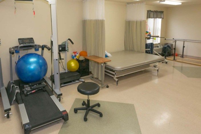 A physical therapy room equipped with exercise equipment and rehabilitation tools.