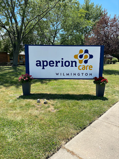 A sign for Aperion Care located in Wilmington, surrounded by landscaped areas.