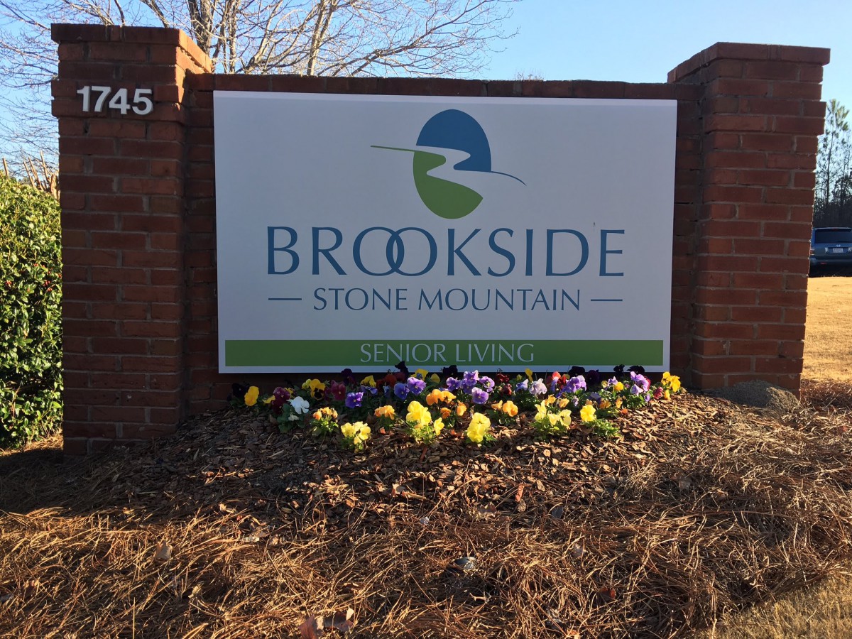 Entrance sign for Brookside Stone Mountain surrounded by flowers.