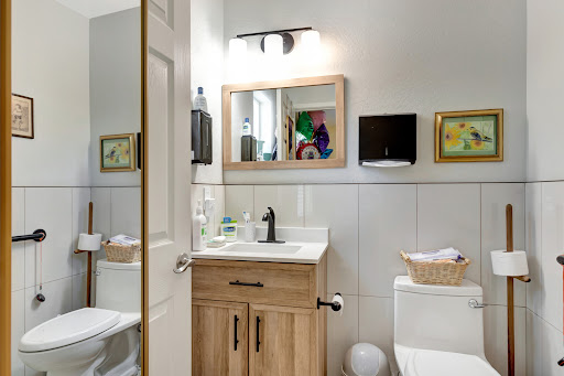 A well-designed bathroom featuring a wooden vanity, stylish mirror, and decorative elements.