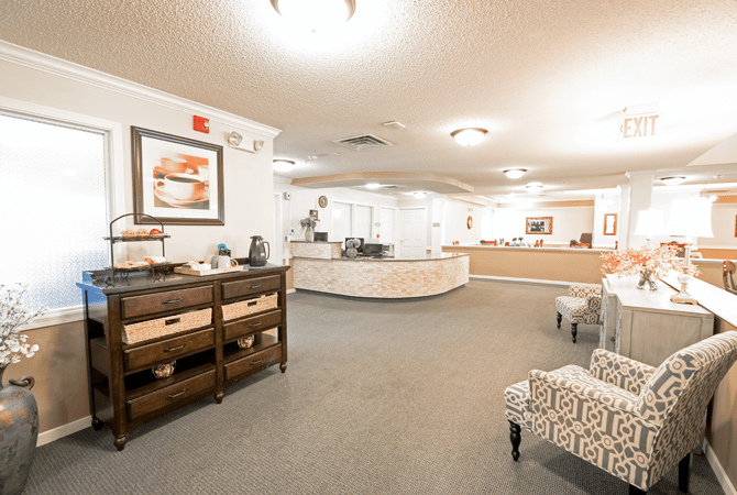 A well-lit reception area with a desk and comfortable seating.