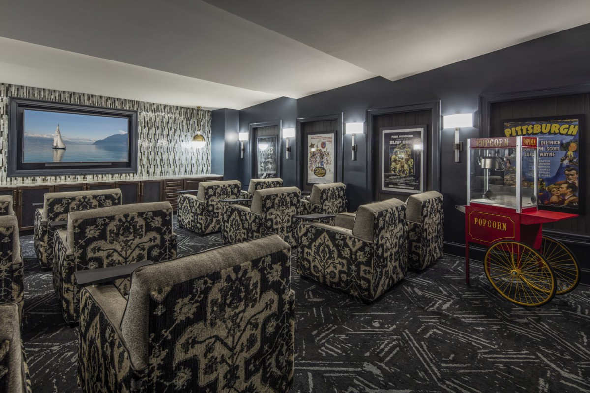 A luxurious home theater room with plush, patterned seating and elegant wall decorations.