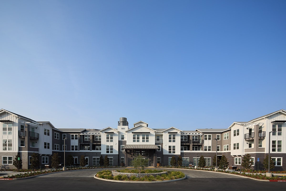 Modern residential building with a clear blue sky backdrop.