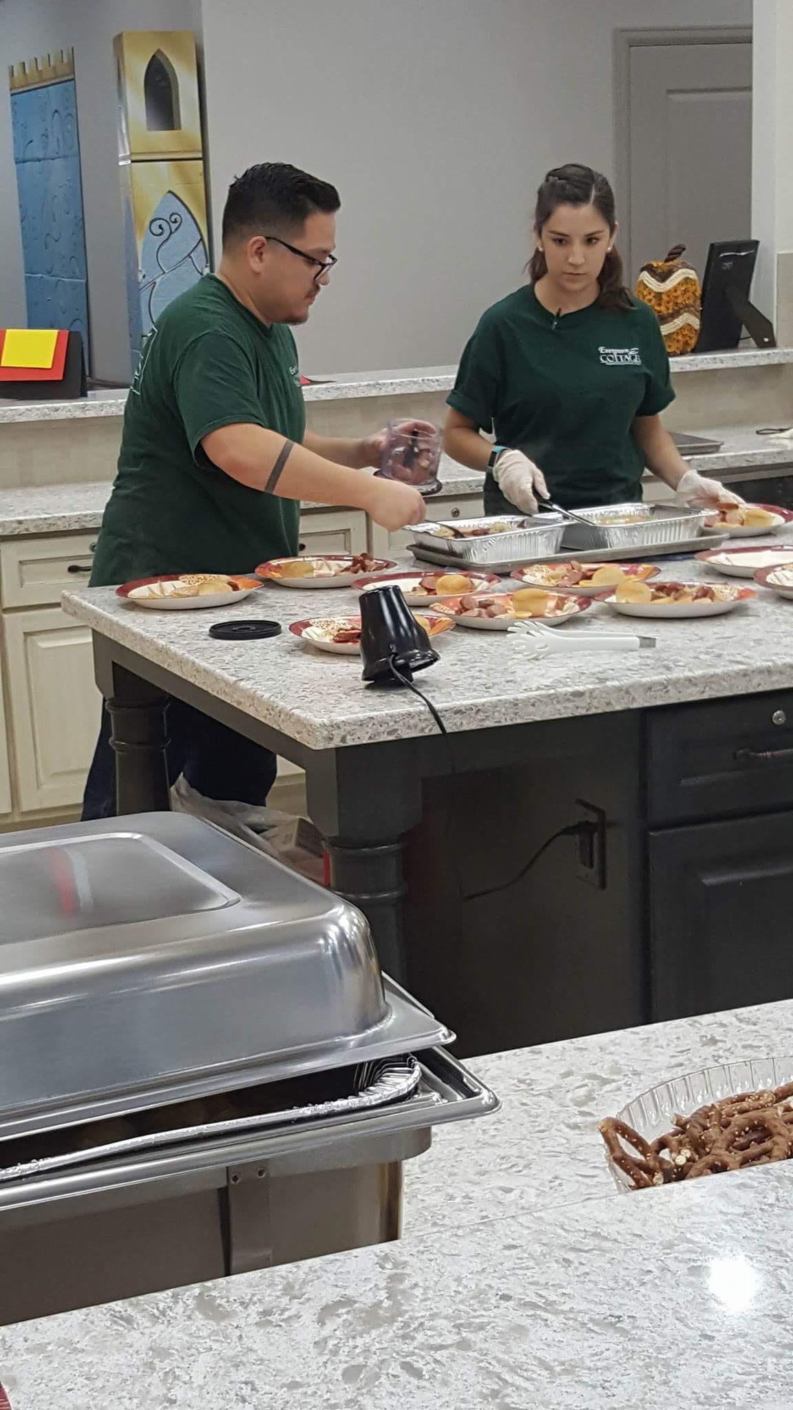 Chefs preparing and plating dishes in a commercial kitchen.
