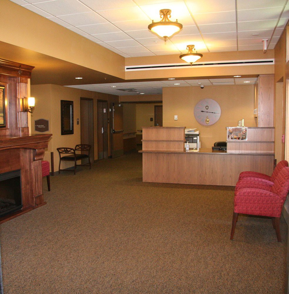 A lobby with a reception desk, seating, and warm lighting.