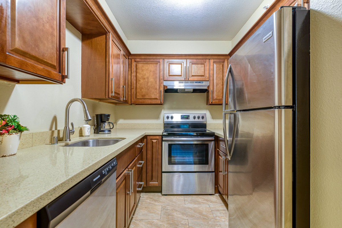 A modern kitchen with wooden cabinets and stainless steel appliances.