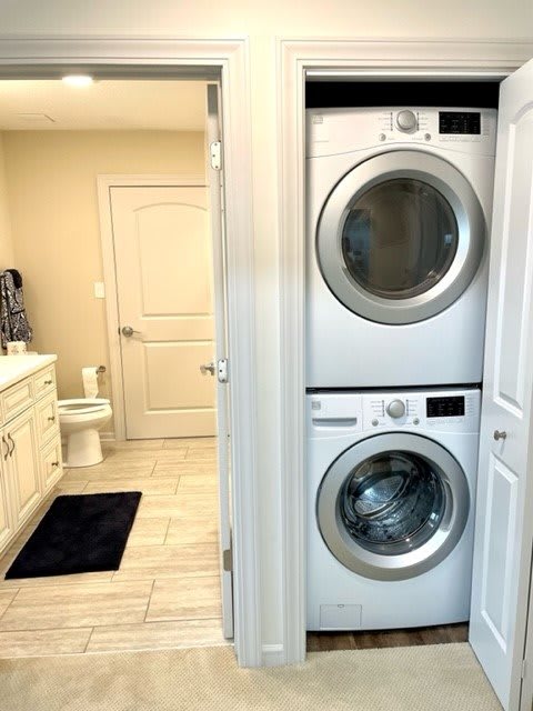 A modern bathroom with a stacked washer and dryer unit.