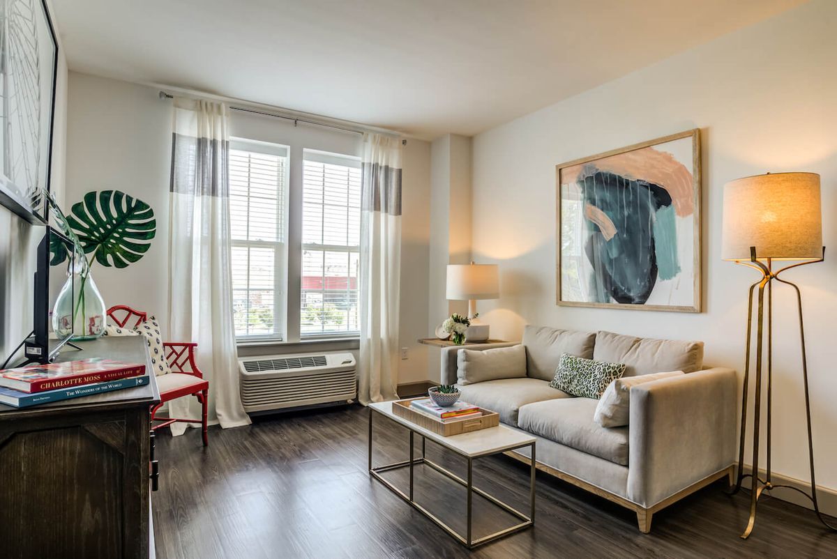 A modern living room with a cozy sofa, stylish artwork, and a coffee table.