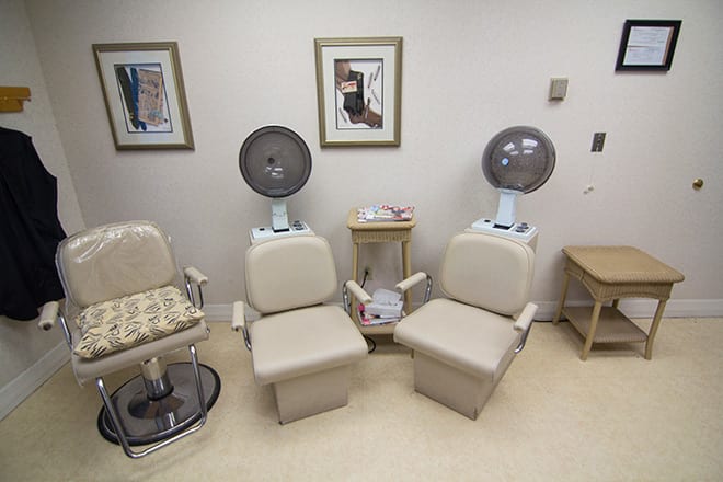 An interior view of a hair salon with salon chairs and hair dryers.