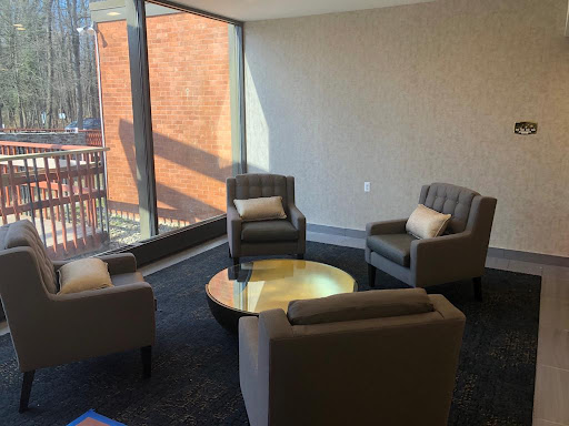 A cozy lounge area featuring modern furniture and ample natural light.