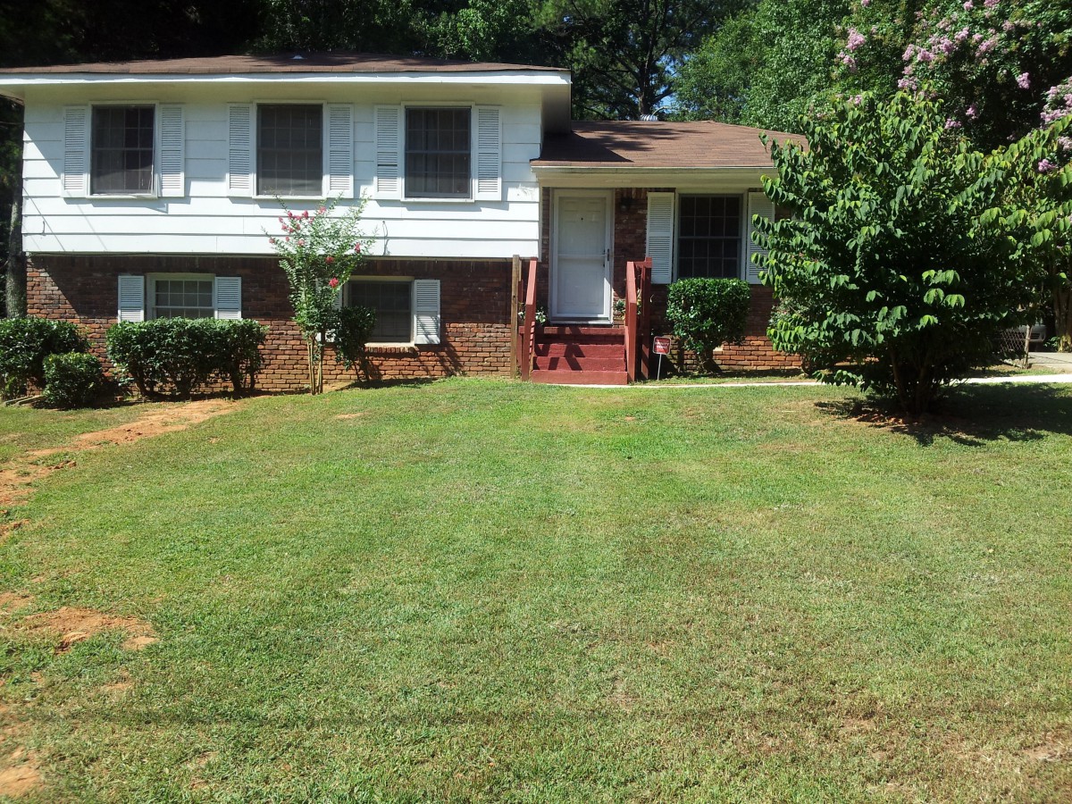 A suburban house with a well-maintained lawn and trees.