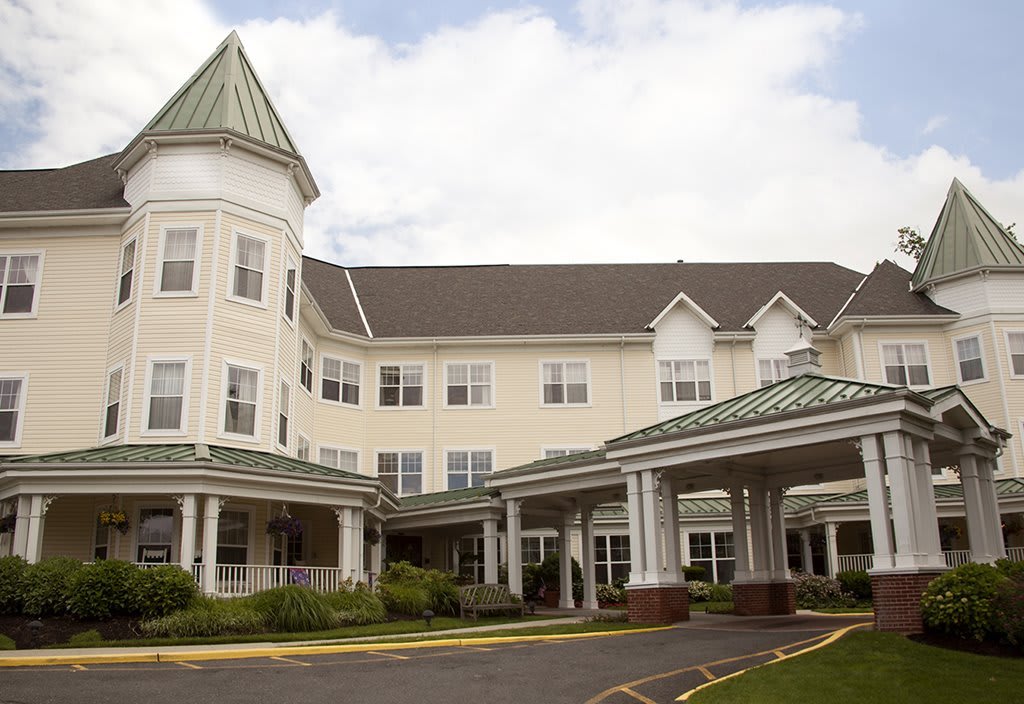 An exterior view of a senior living residential building with a welcoming entrance.